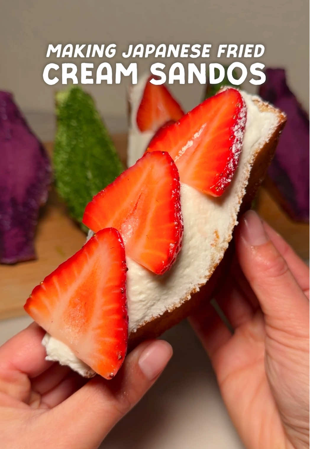 Deep fried cream sandos filled with whipped cream and topped with powdered sugar and strawberries