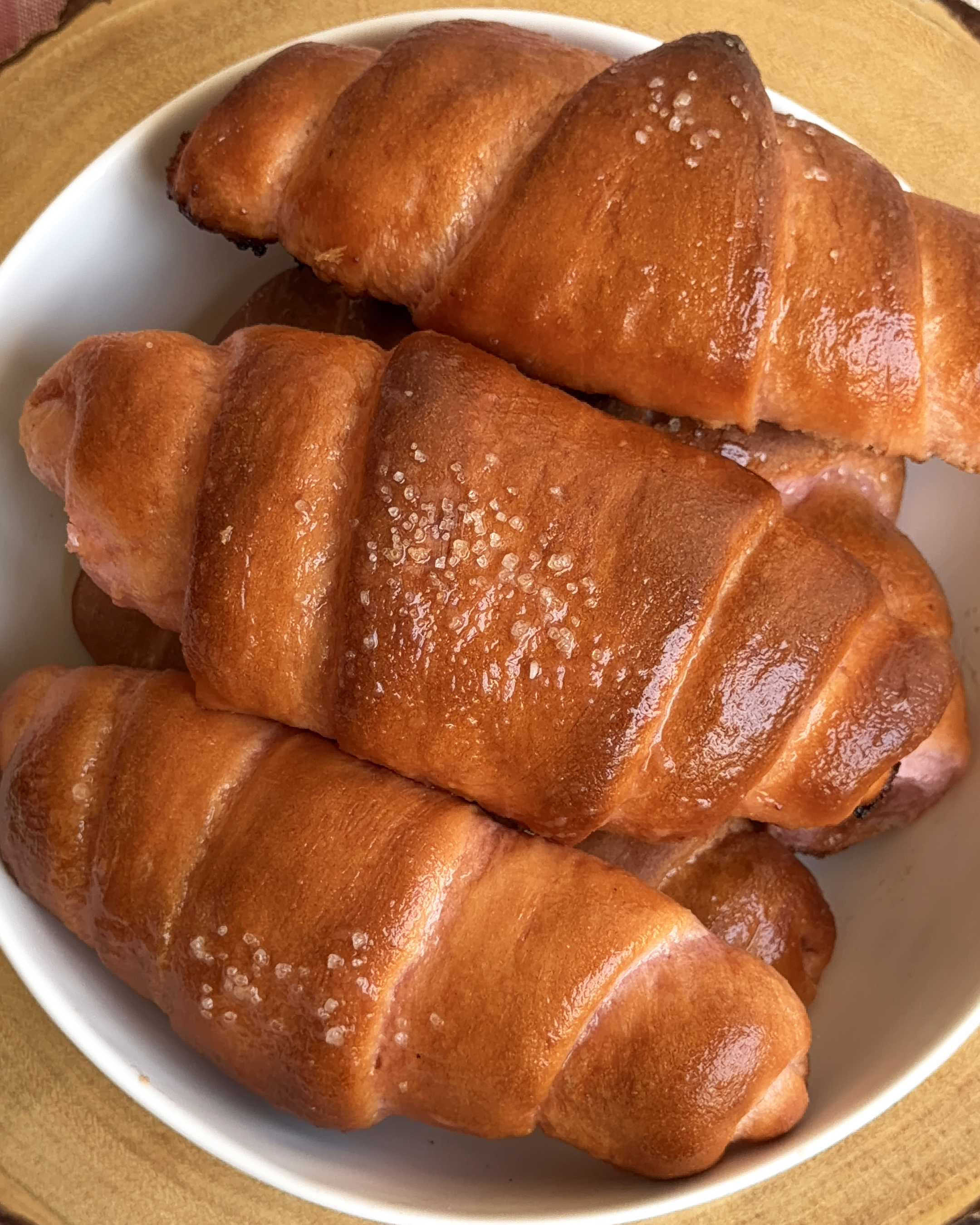 Freshly baked pink guava salt bread rolls topped with pretzel salt