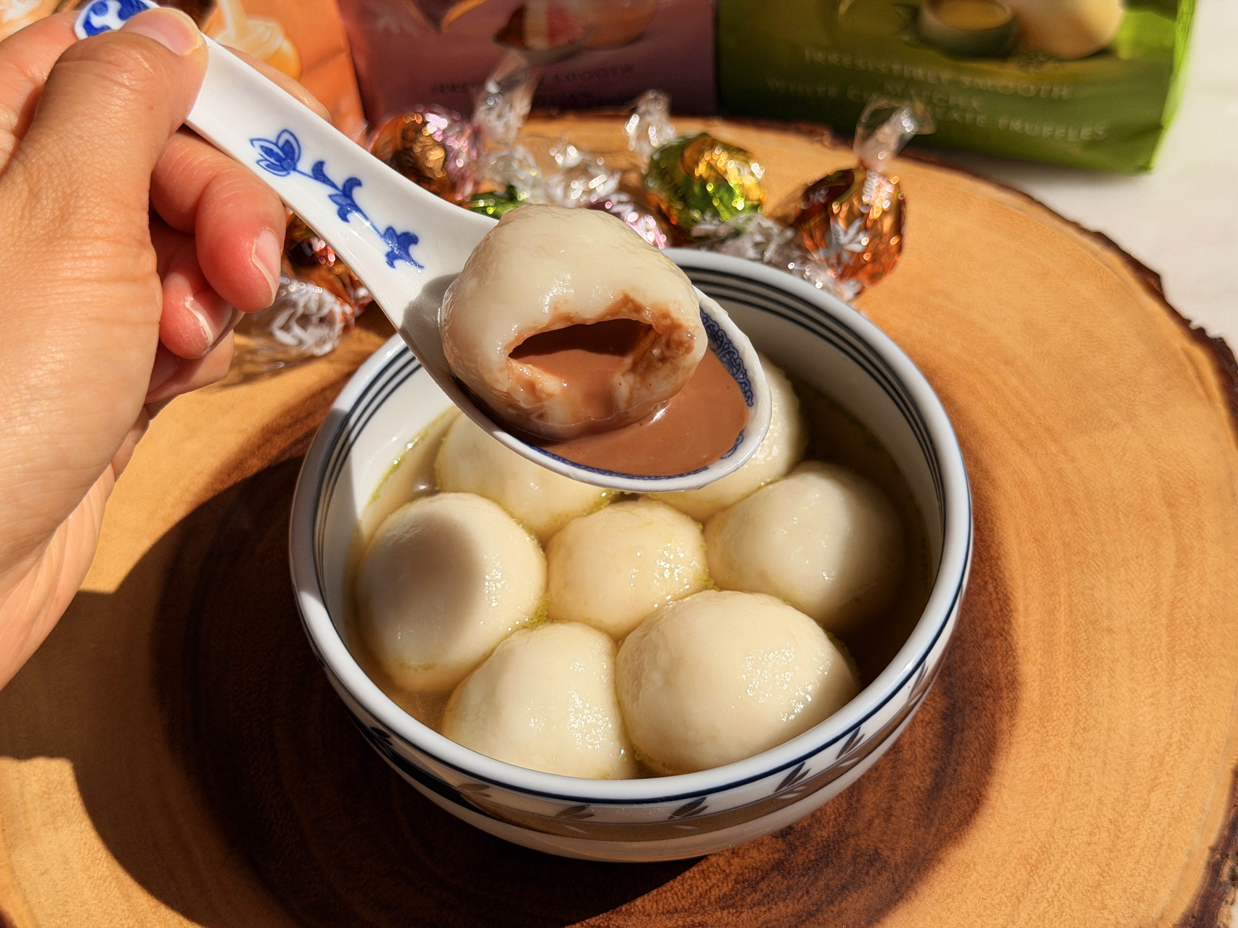 A bite of chocolate-filled tang yuan showing the molten center